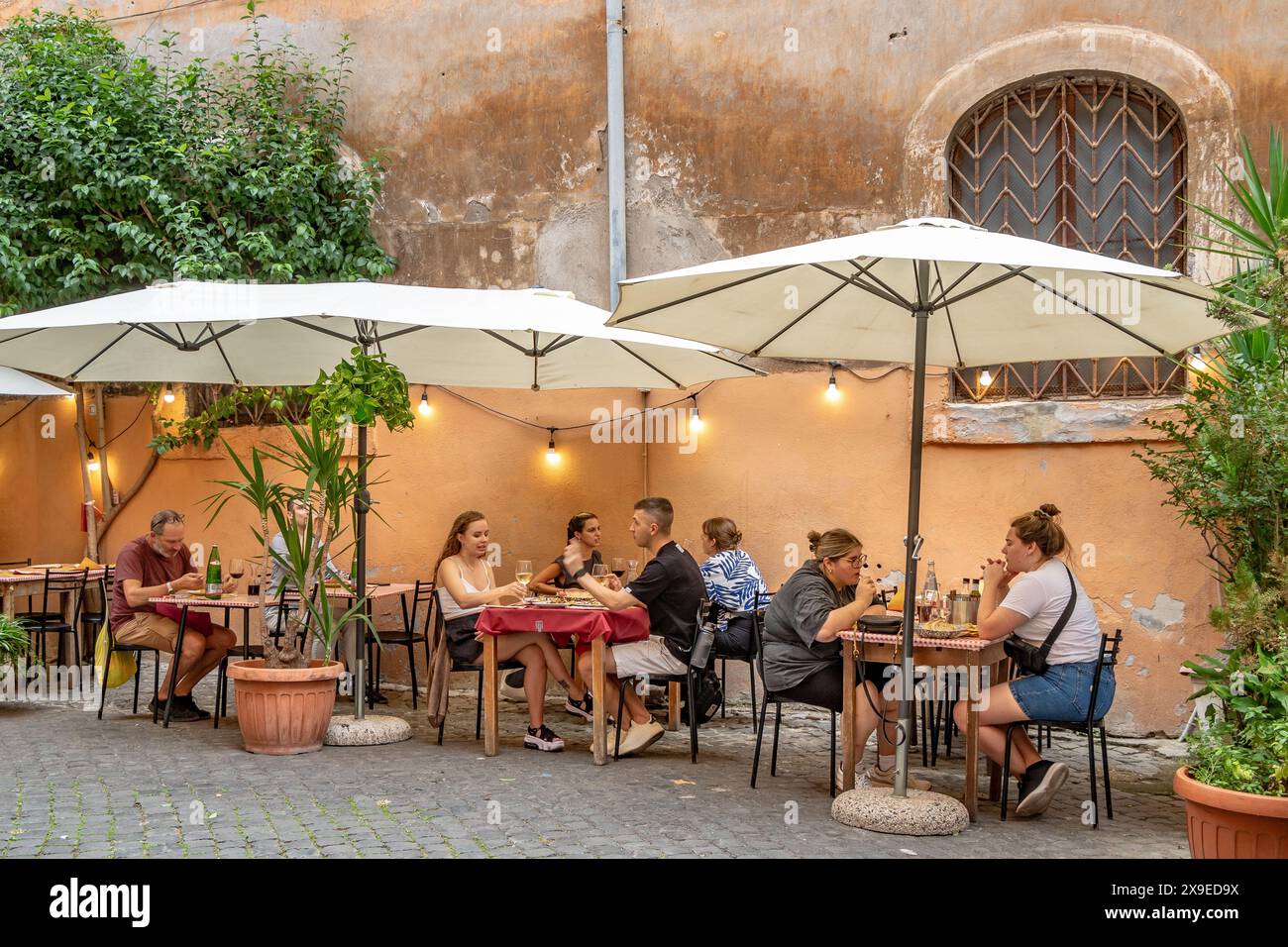 Die Leute saßen draußen und aßen in einem Restaurant in Trastevere, einem beliebten Viertel von Rom, Italien Stockfoto