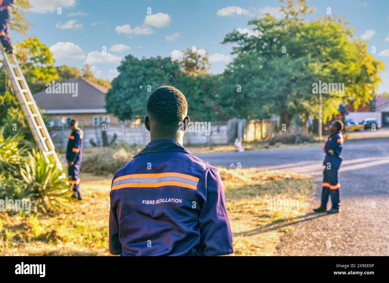 Installation von Glasfaser im Freien, drei afrikanische Techniker, in Wohngebieten Stockfoto Installation von Glasfaser im Freien, drei afrikanische Techniker, in Wohngebieten Stockfoto