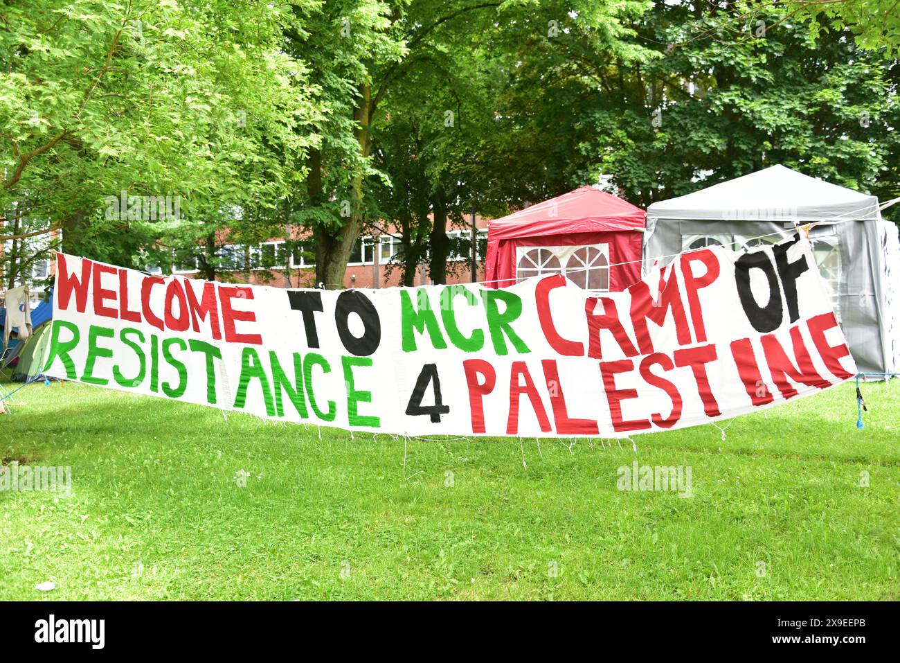 Pro-palästinensische Proteste und Sitzen im Whitworth Hall Campus Gebäude an der University of Manchester, Großbritannien. Banner begrüßt das „Camp of Resistance 4 Palestine“ im Brunswick Park auf dem nahegelegenen Universitätsgelände. Stockfoto