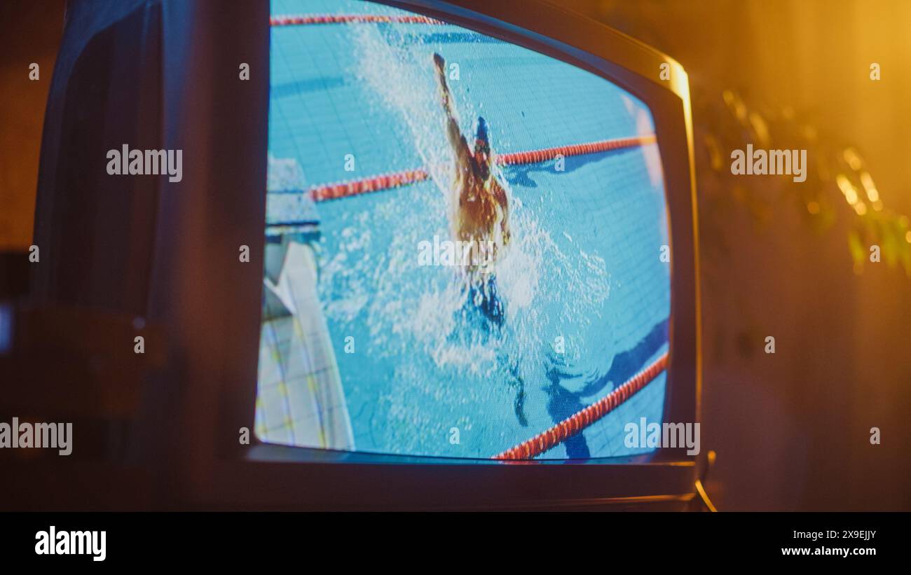 Nahaufnahme eines Retro-Fernsehbildschirms mit Live-Sportwettbewerb. Sportliche Männer, die Aerobic in einem Pool durchführen. Nostalgisch Datiertes Technologiekonzept Der 90Er Jahre. Stockfoto