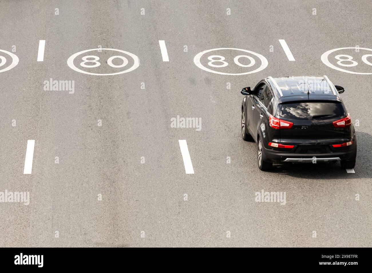 Straßenmarkierungen, die die empfohlene Geschwindigkeit von 80 km/h anzeigen. Straßenmarkierungen, die die Fahrgeschwindigkeit empfehlen. Fahrbahnmarkierungen Stockfoto