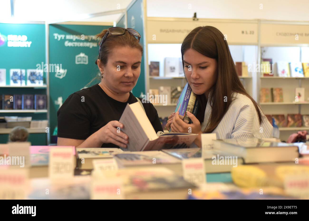 Nicht exklusiv: KIEW, UKRAINE - 30. MAI 2024 - zwei Frauen schauen sich ein Buch beim 12. Book Arsenal International Festival im Mystetskyi Arsenal Natio an Stockfoto