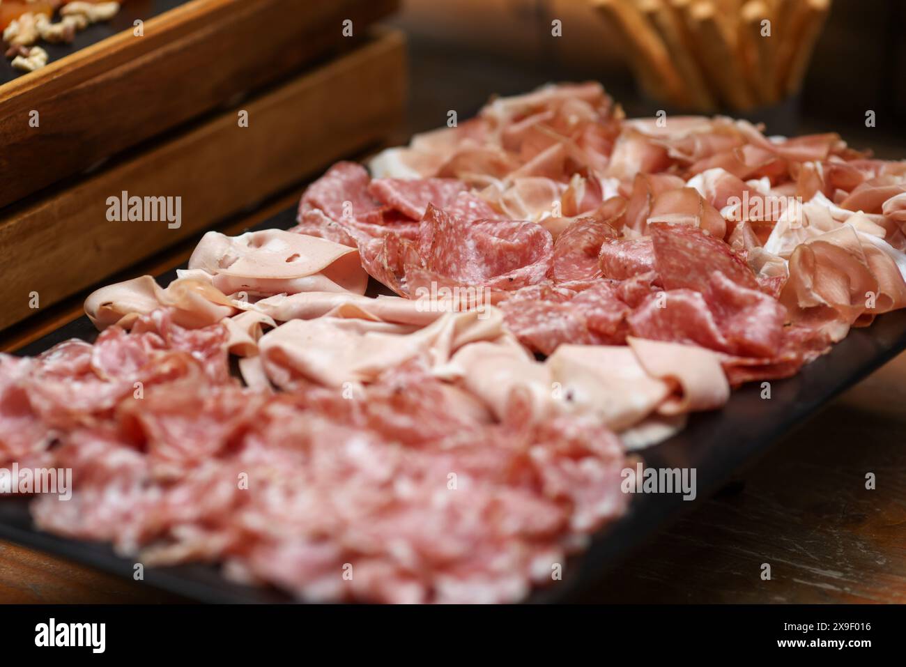 Geringe Schärfentiefe (selektiver Fokus) mit verschiedenen Fleischsorten (Wurstwaren) an einem Buffet. Stockfoto
