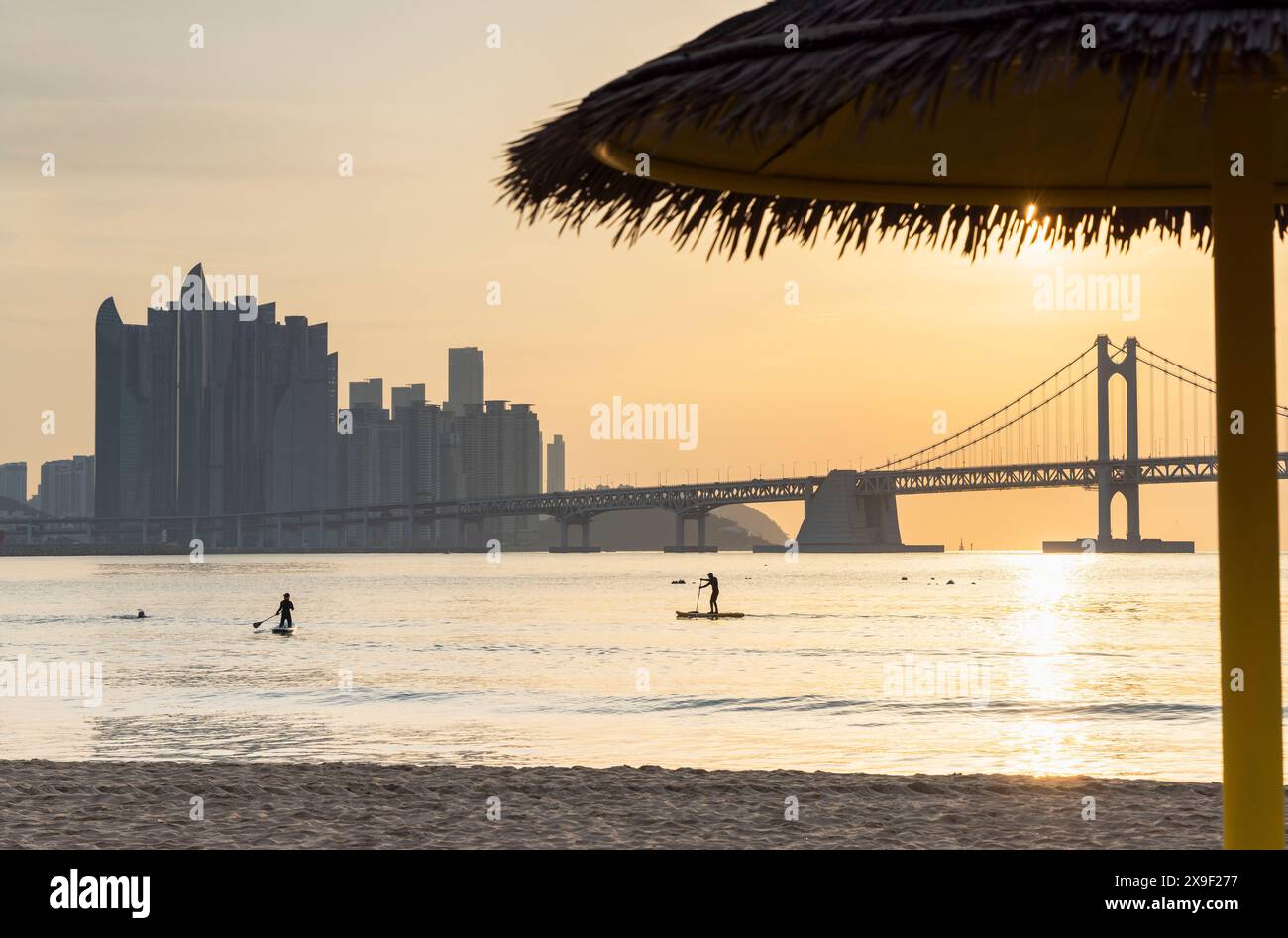 Leute paddeln am Gwangalli Beach bei Sonnenaufgang, Busan, Südkorea Stockfoto