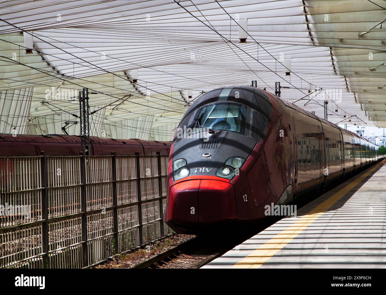 Der Hochgeschwindigkeitszug fährt in den Bahnhof Reggio Emilia AV Mediopadana ein, der in Italien fortgeschrittene Eisenbahnverkehr ist. Stockfoto