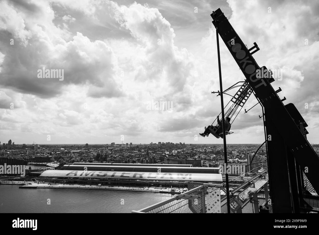Silhouette von zwei Personen auf der größten Schaukel Europas auf dem A'DAM-Turm in Amsterdam (Niederlande), dargestellt in Schwarzweiß am 27. Mai 2024 Stockfoto
