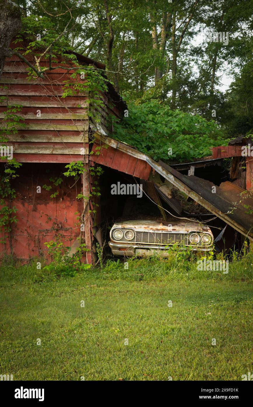 Verlassenes, rostiges Auto in einer baufälligen Scheune Georgia, USA Stockfoto