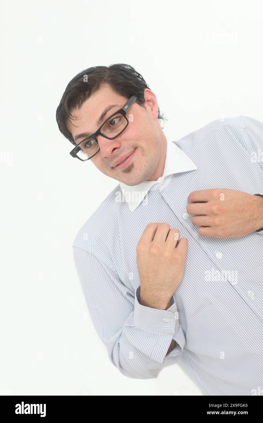 Schüchterner und unsicherer männlicher Nerd, der eine Brille auf weißem Hintergrund trägt Stockfoto