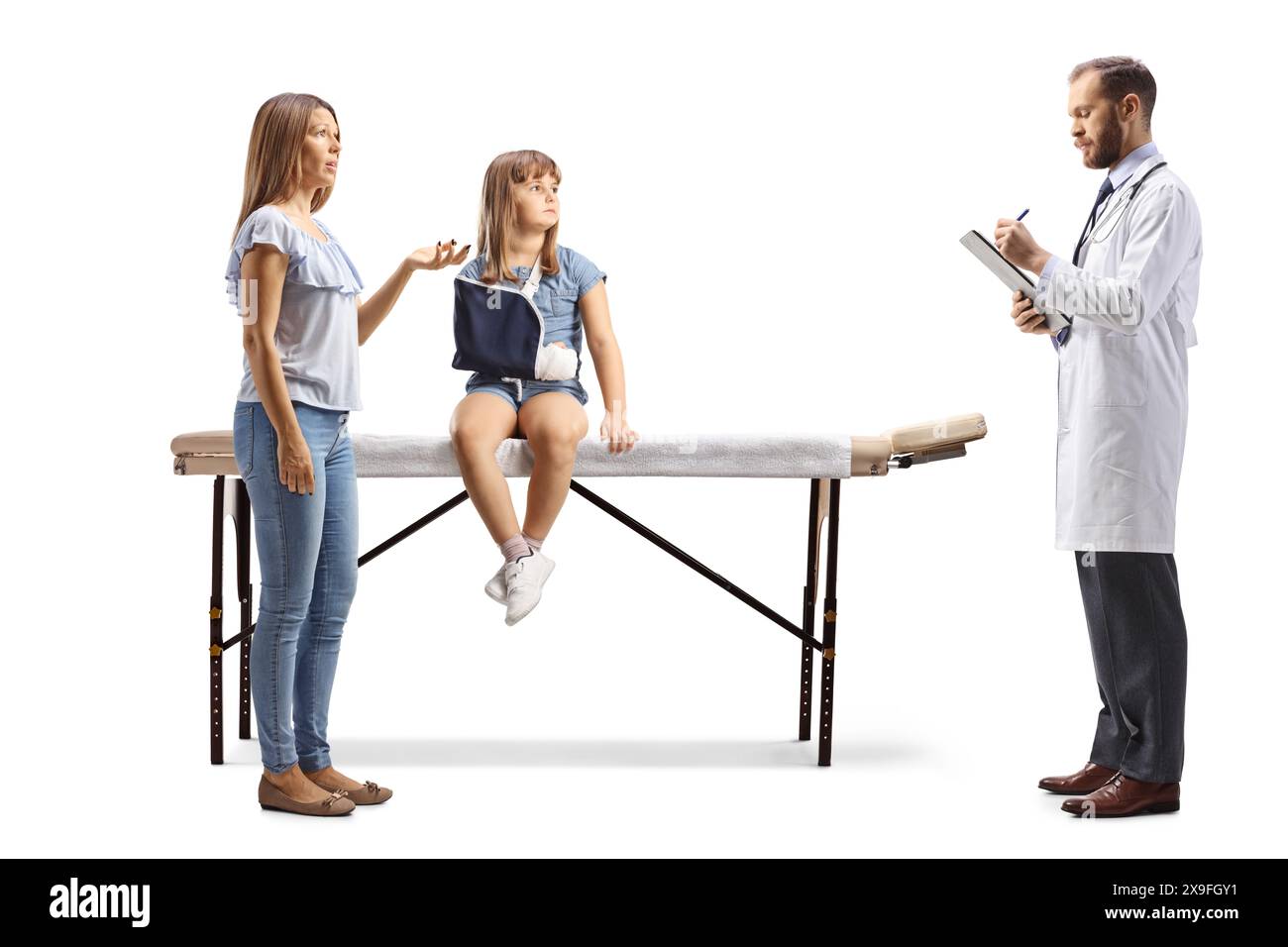 Mutter und Tochter mit gebrochenem Arm in einem Krankenhaus, das mit einem Arzt auf weißem Hintergrund spricht Stockfoto