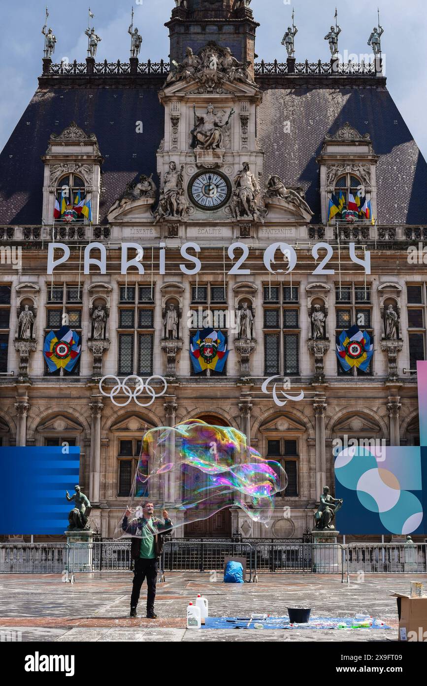 Paris, Frankreich 05.22.2024 Unbekannter Blasenkünstler, der vor dem Pariser Rathaus auftritt. Das Rathaus mit den Olympischen Ringen und Paris Stockfoto