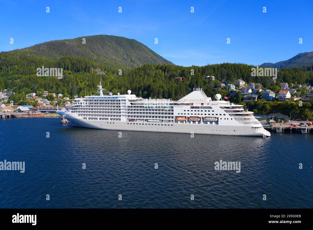 Das Kreuzfahrtschiff liegt in der Innenstadt von Ketchikan, der südlichsten Stadt Alaskas, eingebettet in waldbedeckte Berge am Ufer des Pazifischen Ozeans Stockfoto