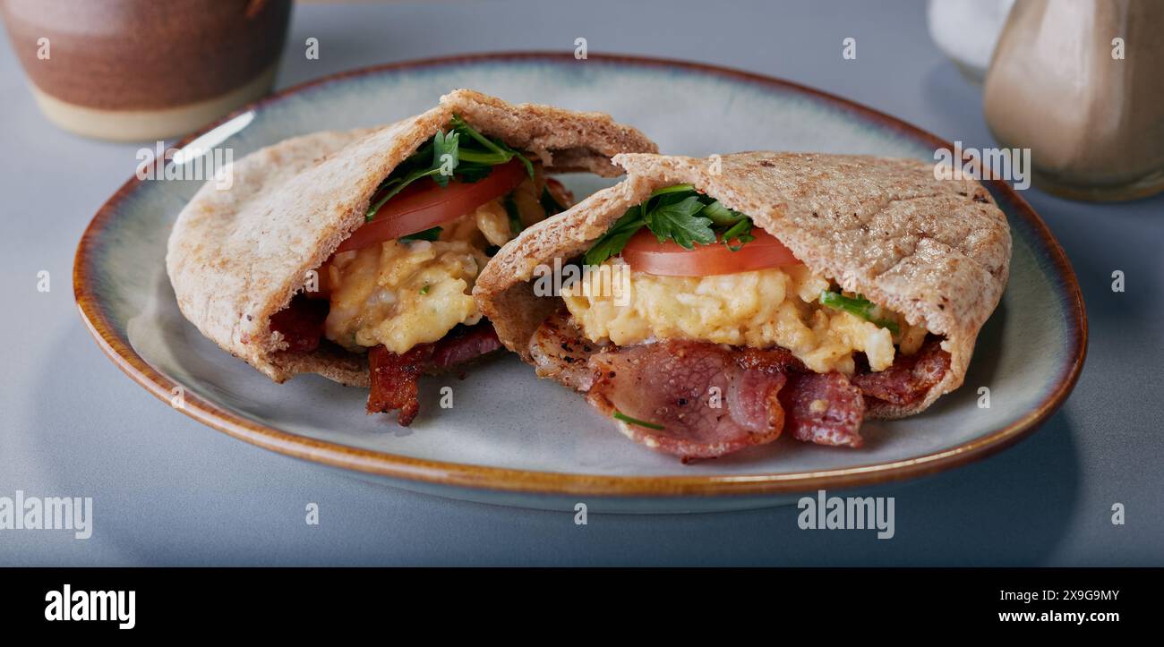 Pitta Brot gefüllt mit Rührei, Speck, Tomaten und Kräutern. Stockfoto
