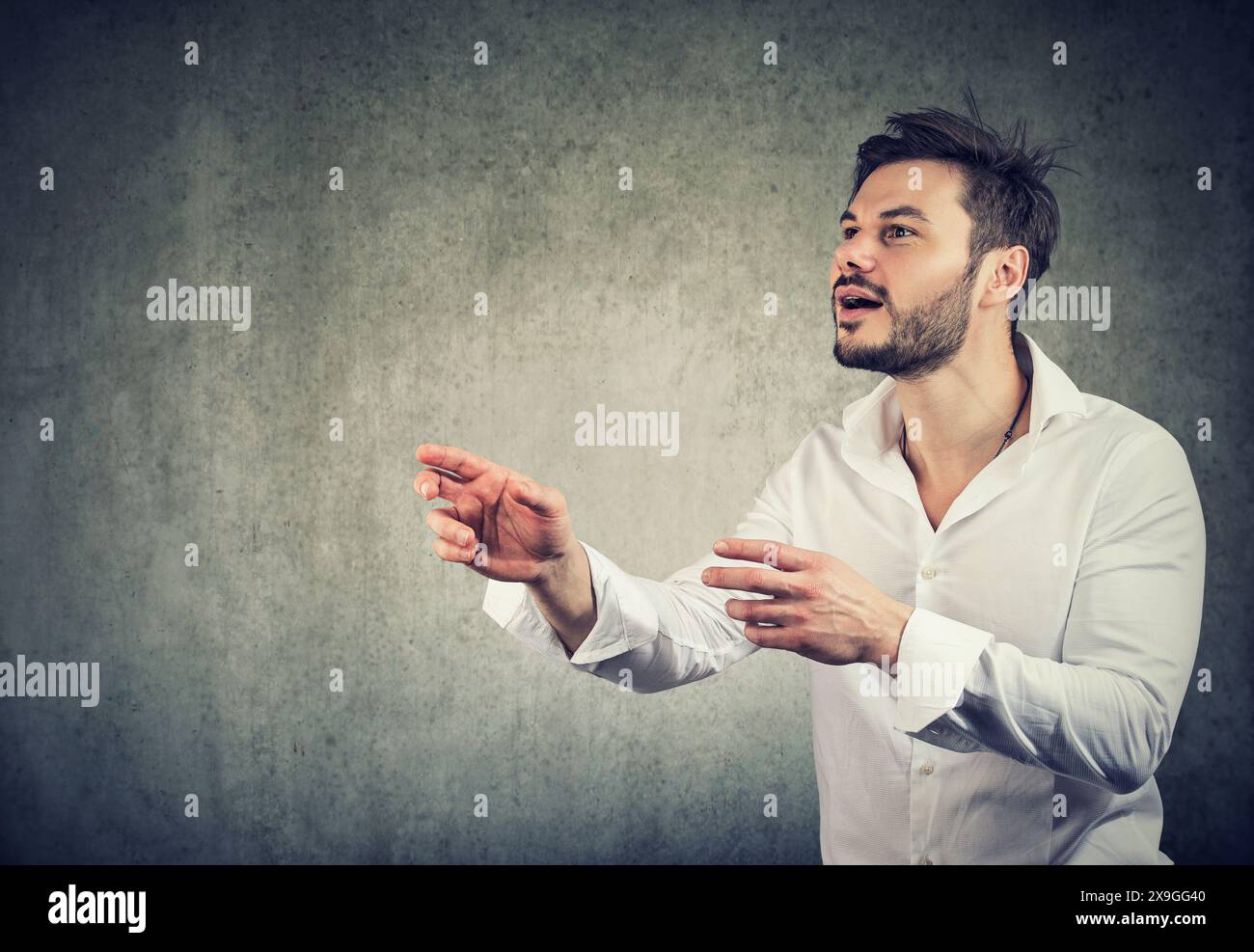 Ein junger Geschäftsmann, der versucht, etwas zu fangen Stockfoto