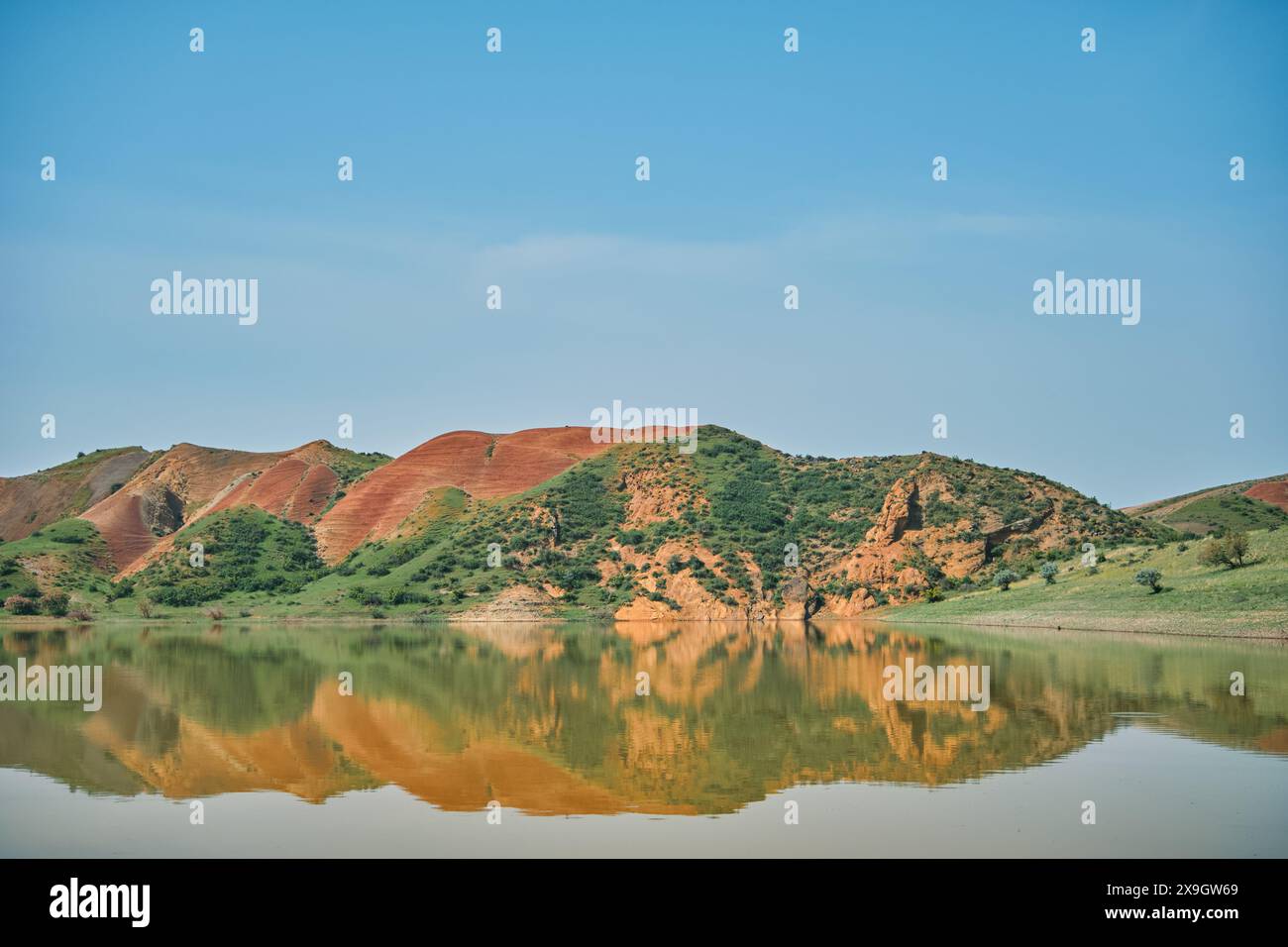 Atemberaubende überirdische Landschaft mit Bergsee und Blick auf rote Berge, malerische und ruhige fremde Landschaft mit Minenraum für Konzept, poste Stockfoto