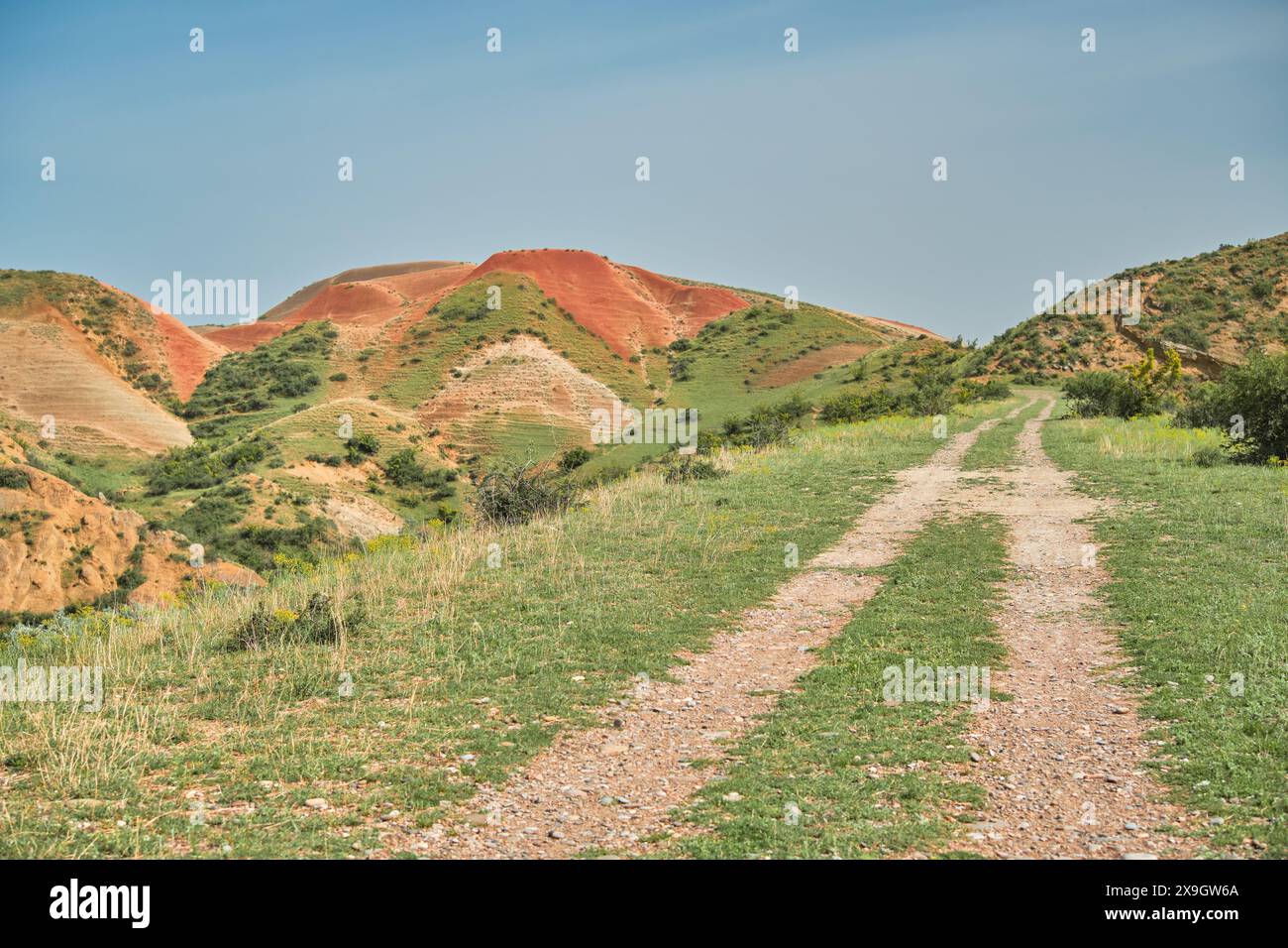 Die Straße, die in die roten Berge führt, lädt Sie ein zu gehen, die atemberaubende Landschaft zeigt die Schönheit der Region Kvemo Kartli, eine Idee für einen po Stockfoto
