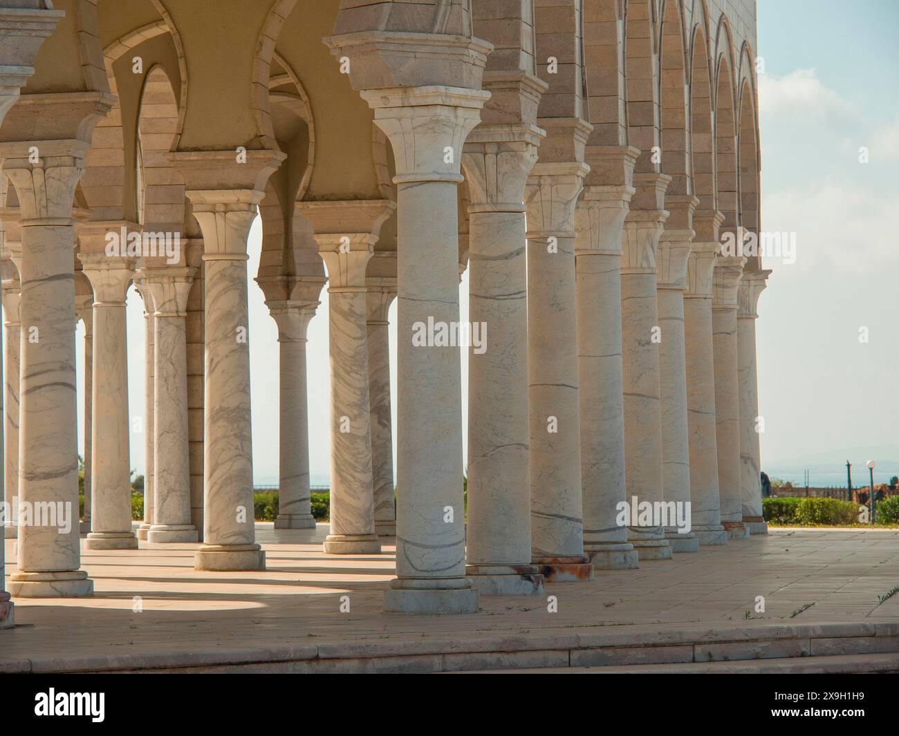 Reihe von Steinsäulen mit Arkadenstruktur, Himmel und Landschaft im Hintergrund, Tunis in Afrika mit Ruinen aus römischer Zeit, moderne Moscheen und Stockfoto