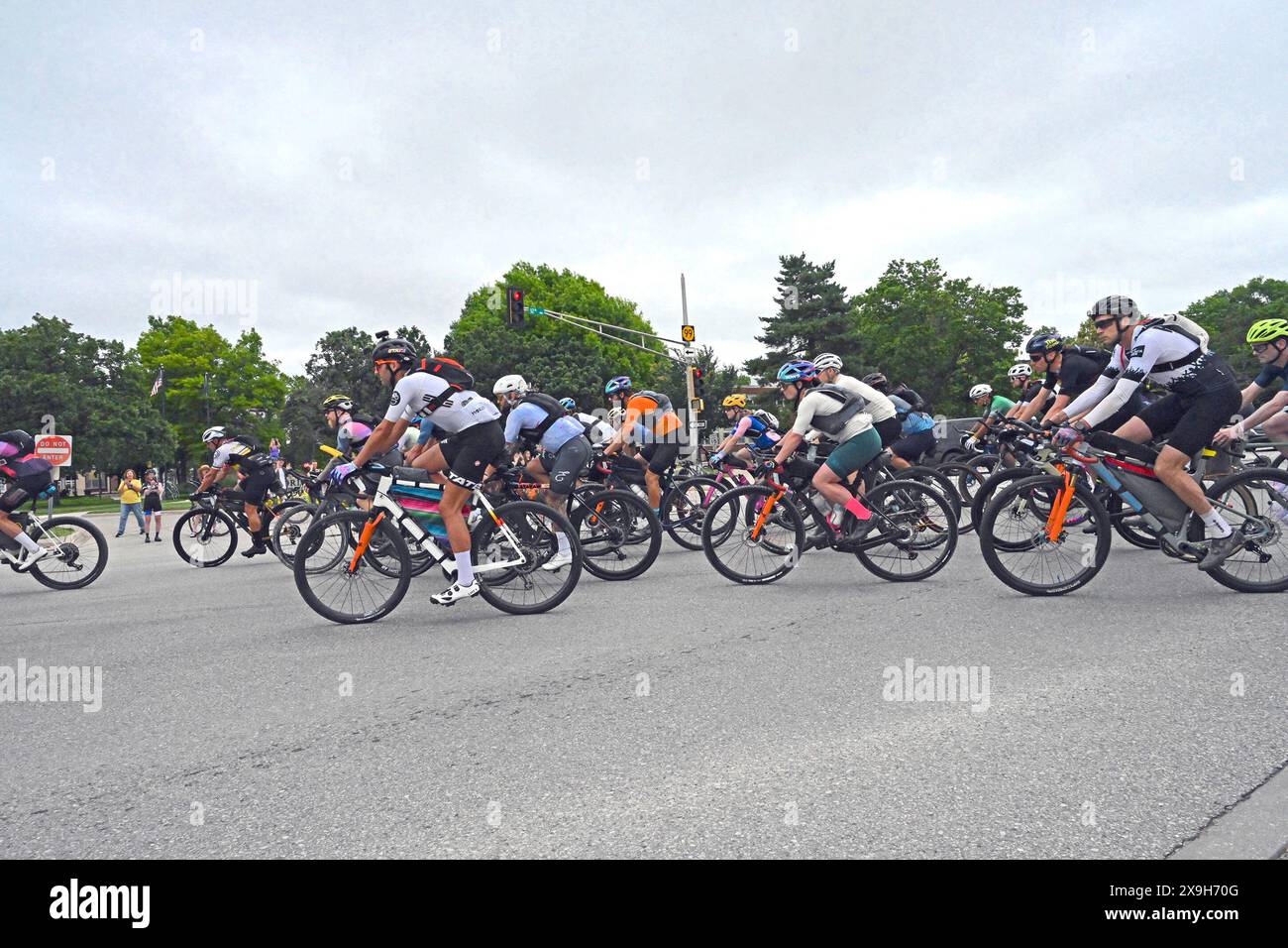 EMPORIA, KANSAS - 31. MAI 2024 der erste von fast 200 Fahrern macht die erste Abbiegung von der Handelsstraße auf den Highway 99 in nördlicher Richtung zu Beginn des Unbound Gravel XL 350 Langstreckenrennens. Stockfoto