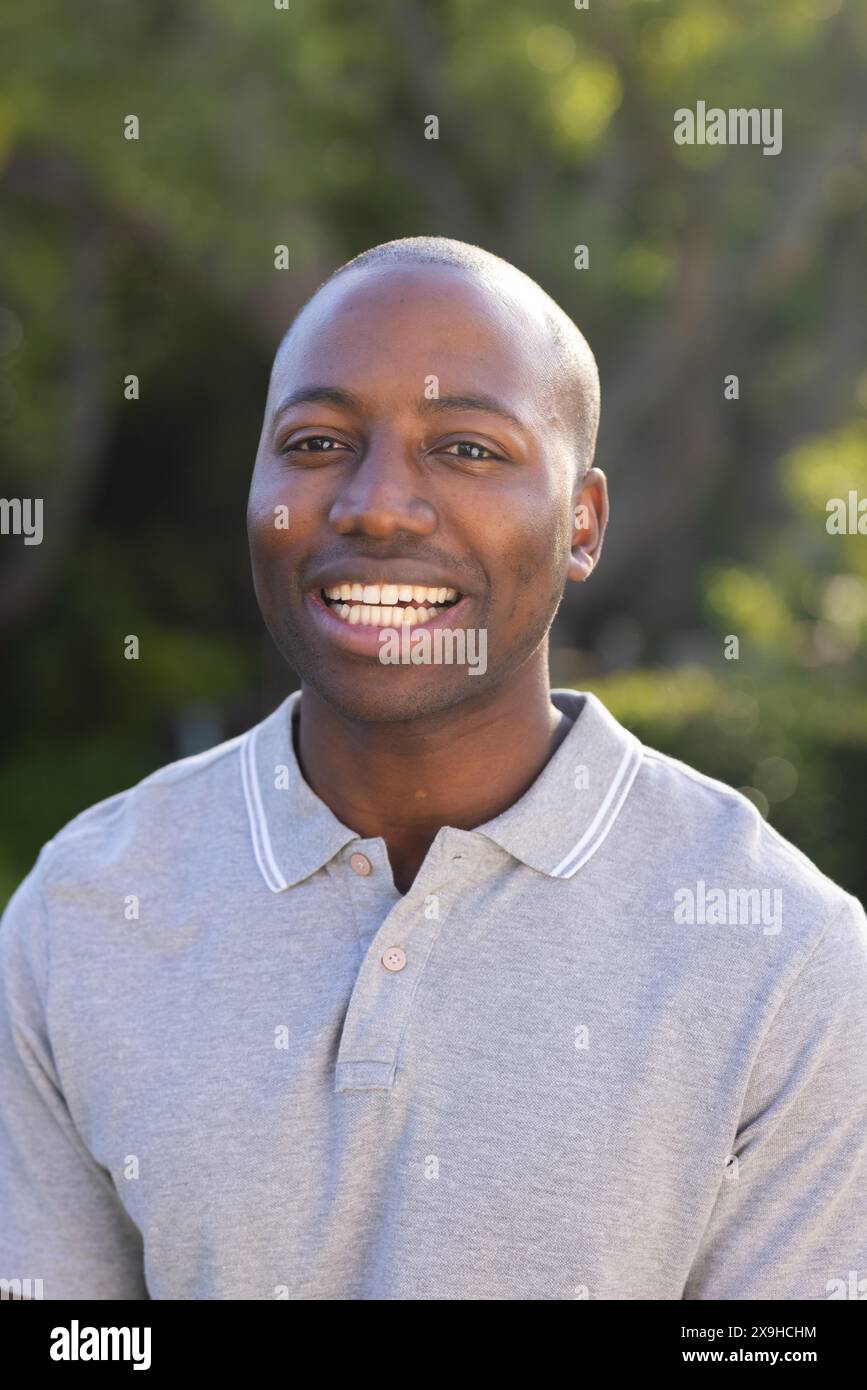 Draußen lächelt der junge Afroamerikaner warm Stockfoto