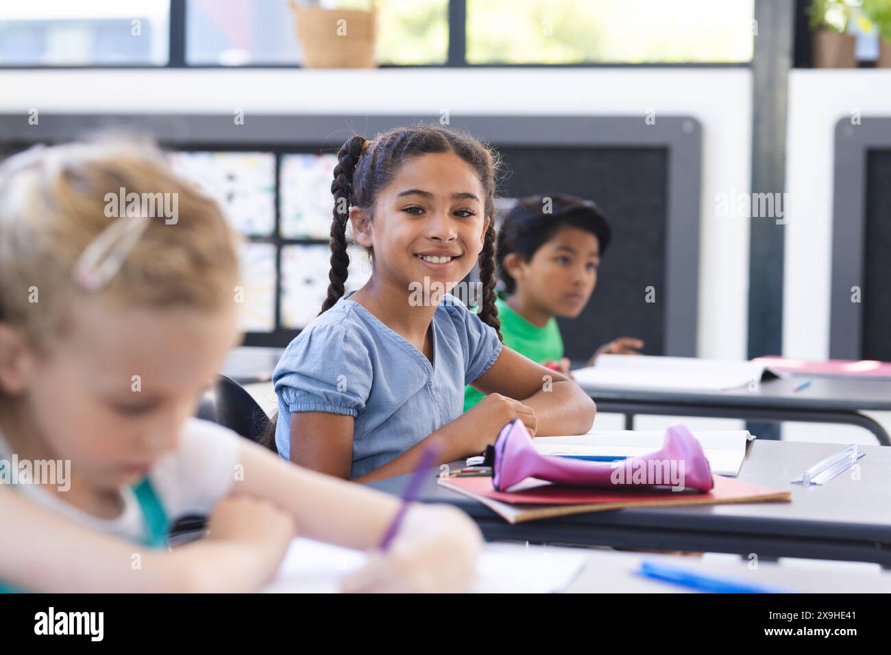 In der Schule gibt es verschiedene Gruppen junger Schüler, die sich auf ihre Arbeit im Klassenzimmer konzentrieren Stockfoto