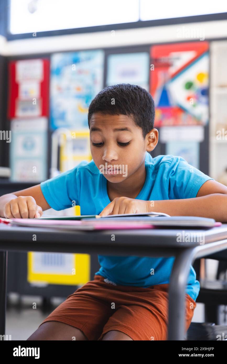 Birassischer Junge, der sich auf das Lesen eines Buches in der Schule konzentriert Stockfoto