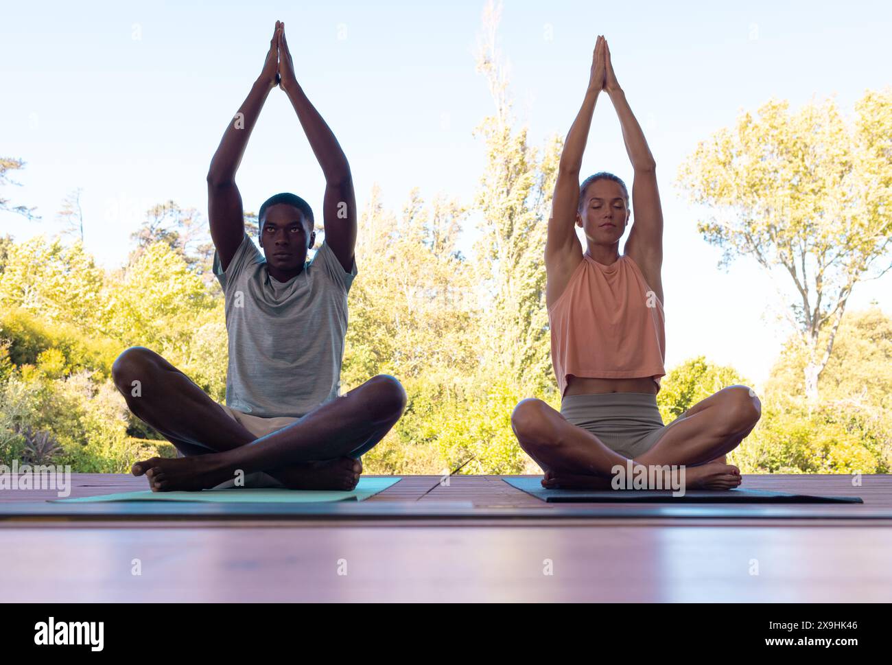 Ein vielfältiges junges Paar, das draußen Yoga praktiziert Stockfoto