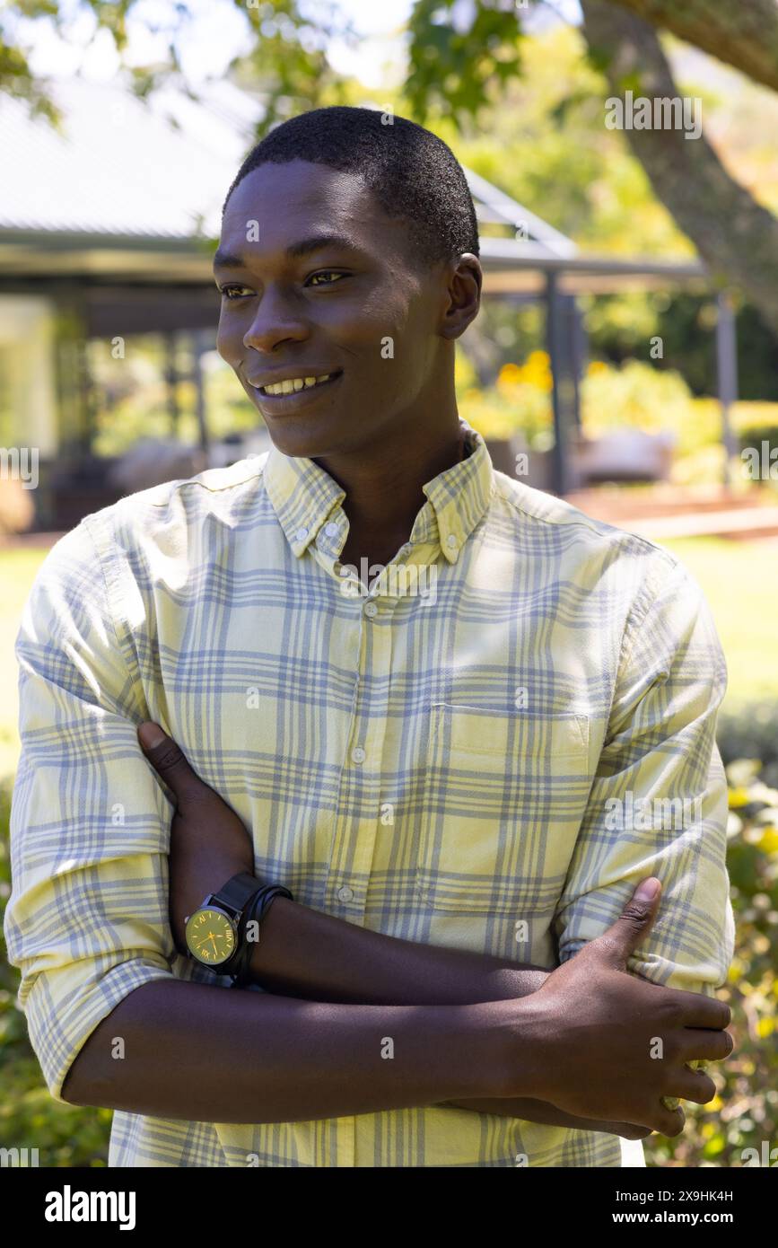 Junger Mann aus Afroamerikaner mit gelbem kariertem Hemd, der draußen steht Stockfoto