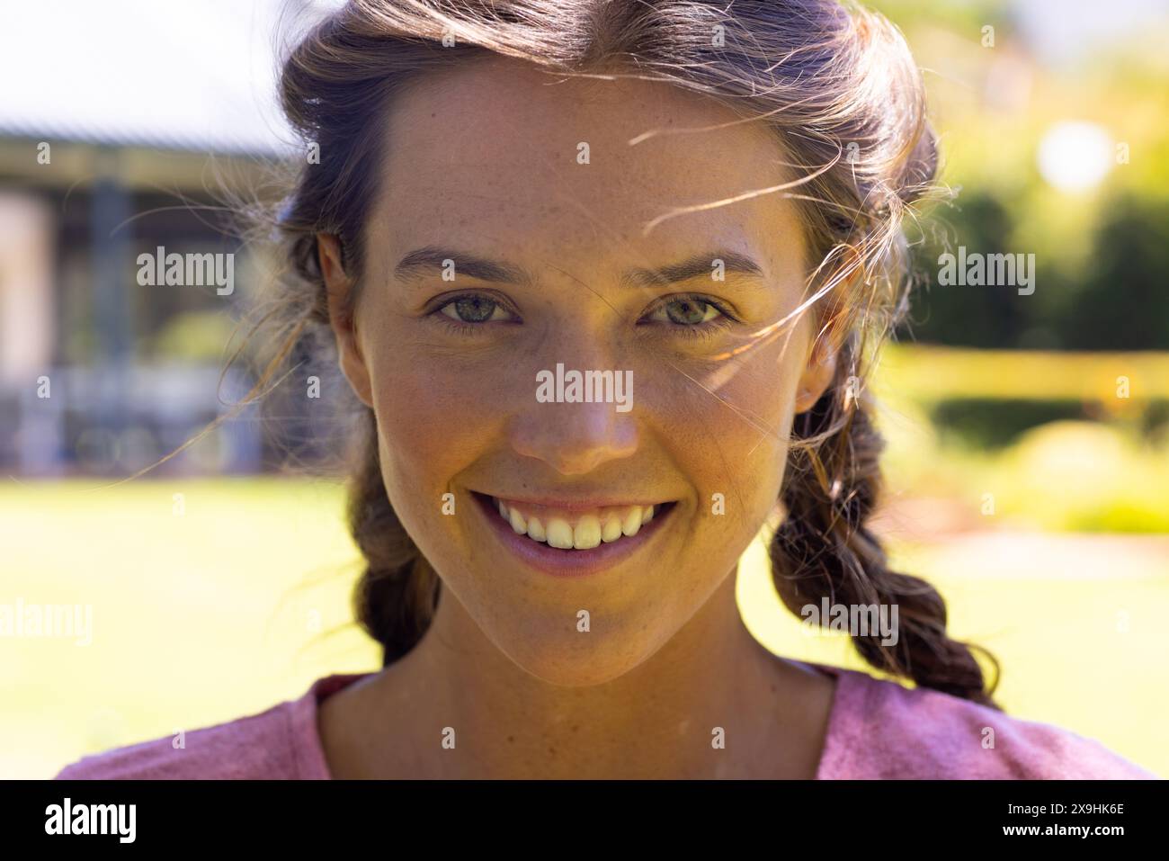 Eine weiße junge Frau in rosa Spitze, die draußen Sonnenschein genießt Stockfoto