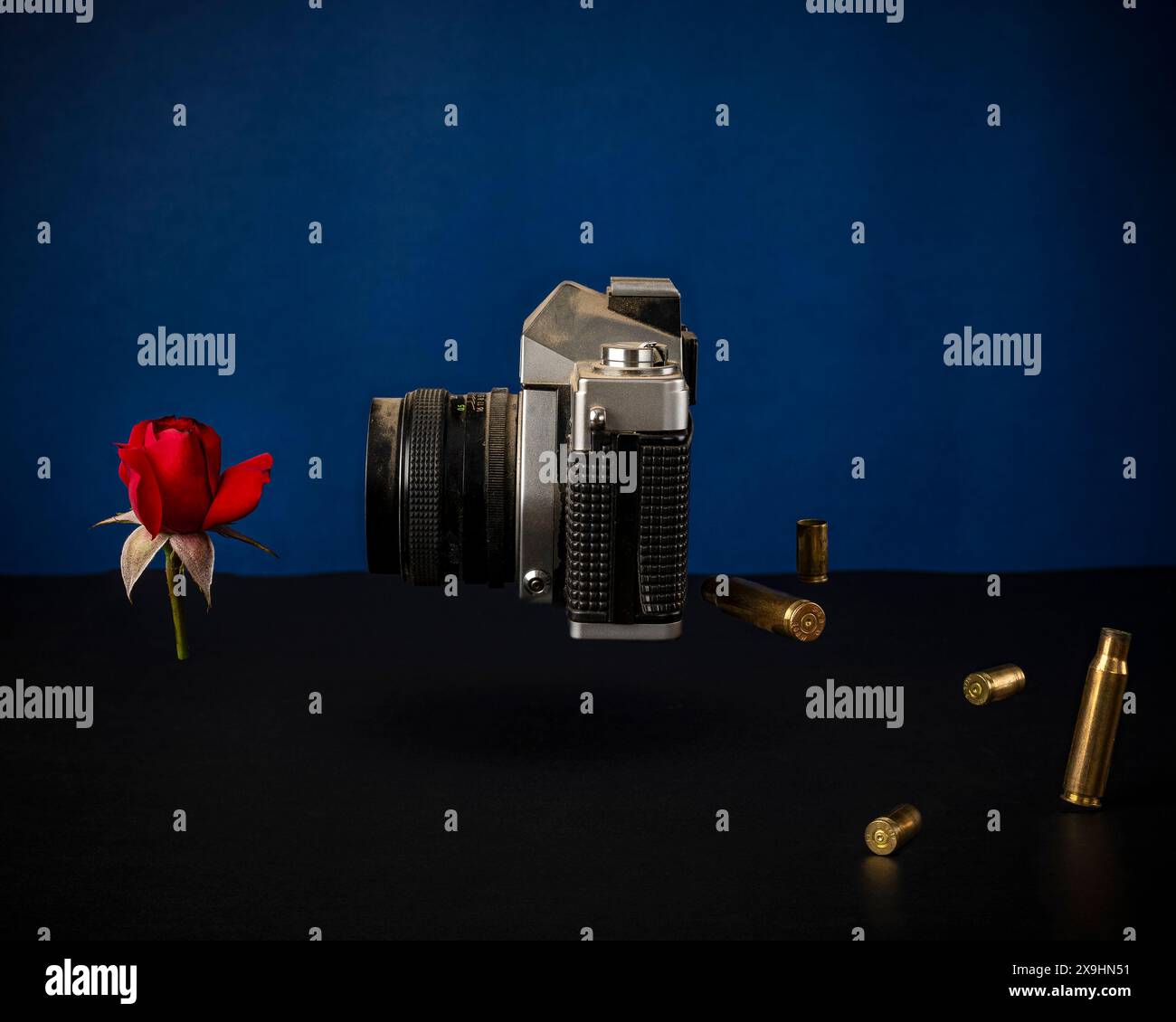 Fake-News-Konzept, Kamera schießt eine Rose und spuckt Kugeln, Studio-Aufnahme Stockfoto