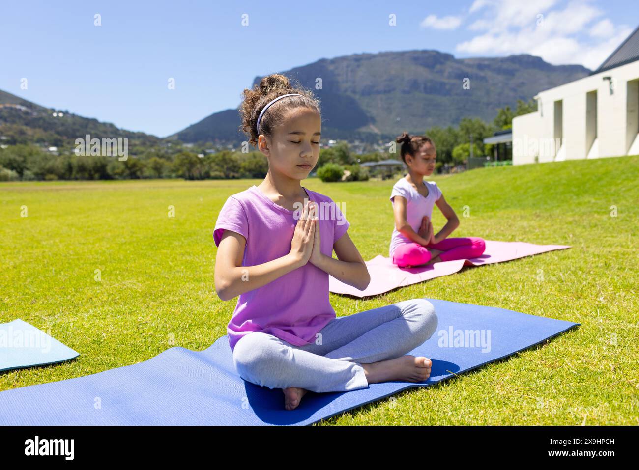 Zwei Frauen üben an einem sonnigen Tag im Freien Yoga Stockfoto