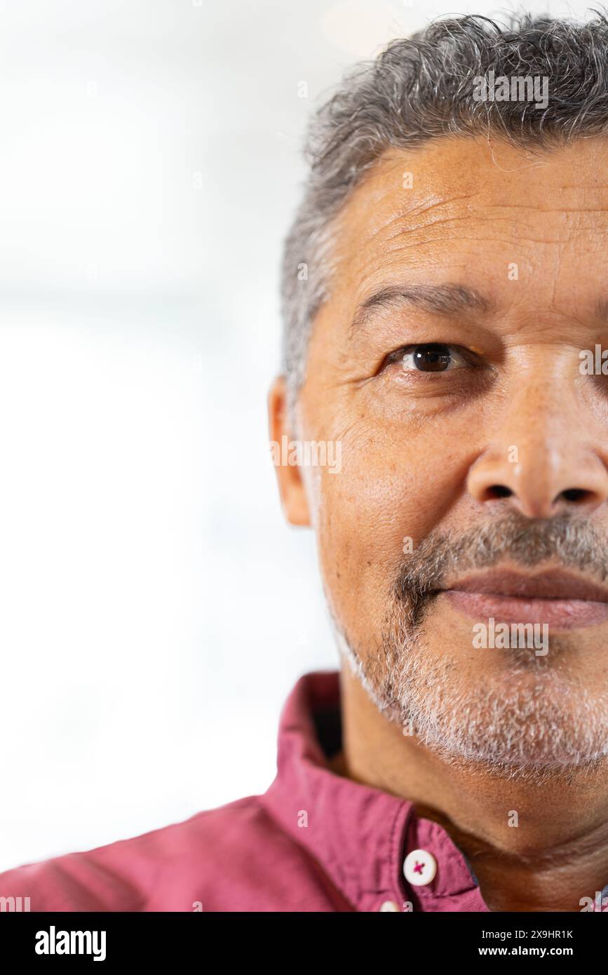 Zu Hause, zweirassiger älterer Mann mit kurzen grauen Haaren und Bart, der drinnen steht, Kopierraum. Rotes Hemd tragen und direkt in die Kamera schauen mit einem neuen Stockfoto