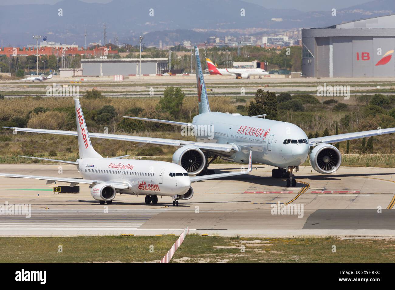 Barcelona, Spanien - 14. April 2024: Air Canada Boeing 777-300ER und Jet2 Boeing 737 auf dem Rollweg am Flughafen El Prat in Barcelona, Spanien. Stockfoto