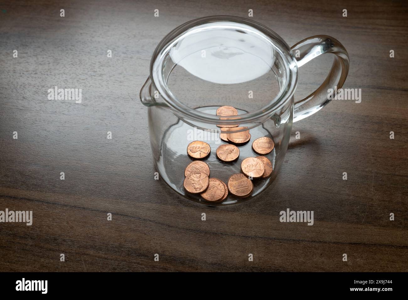 Ein Glasbehälter, eine Geldbox, mit einem Cent, Dollar-Cent, US-Währung, Symbol für Armut Stockfoto