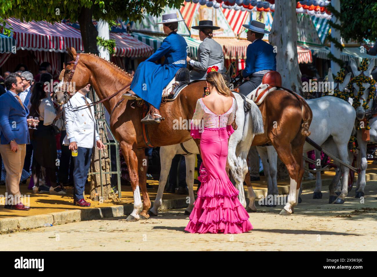 Reiterinnen sprechen mit Freunden in den Festzelten und Casetas während der Aprilmesse in Sevilla, Feria de Abril, die in Spanien gefeiert wird. Stockfoto