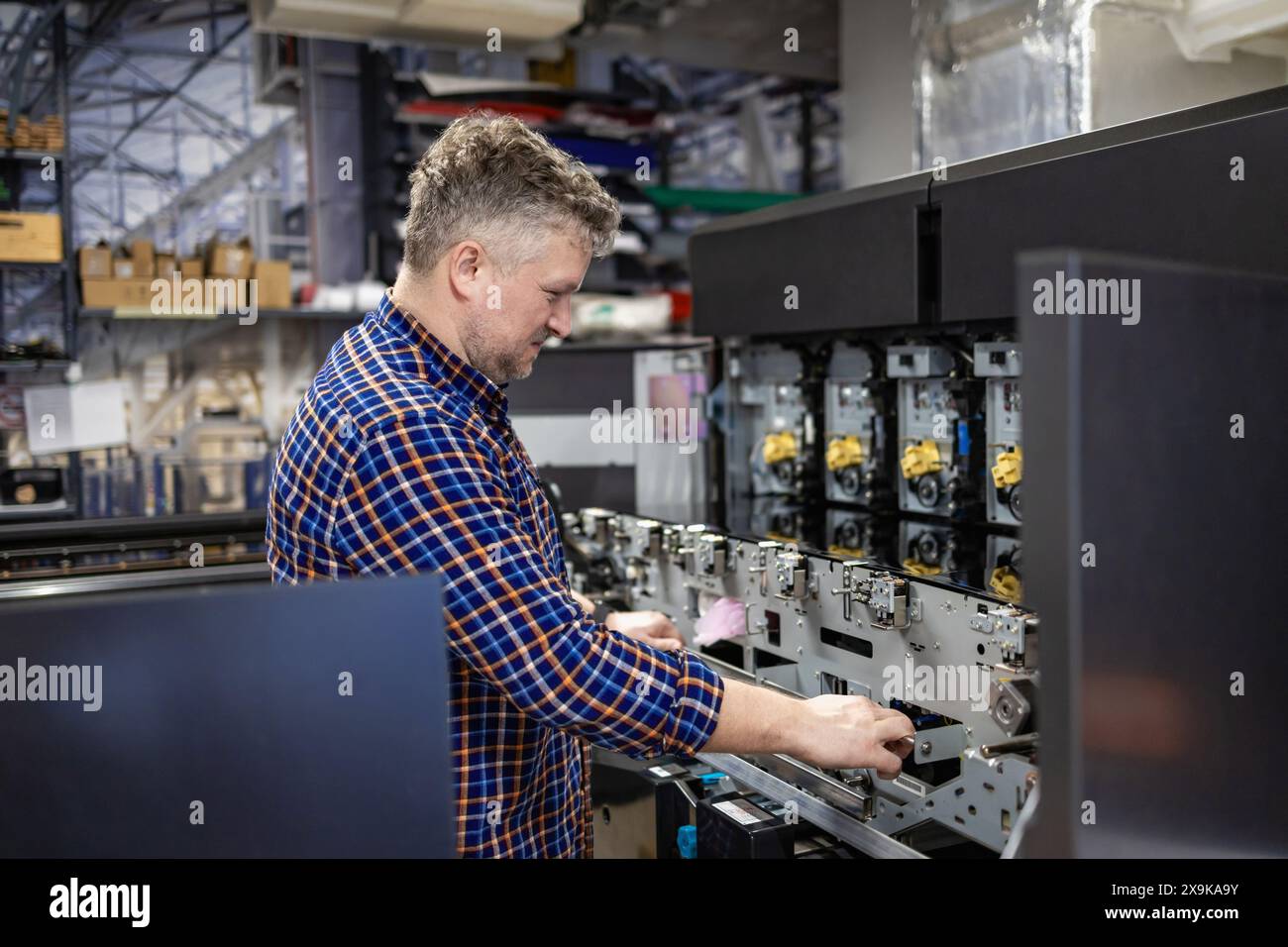 Wartungstechniker in einer Reparaturmaschine in einer Druckerei Stockfoto