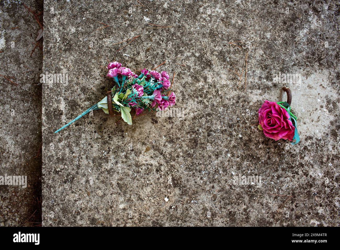 Plastikblumen auf Grab Stockfoto