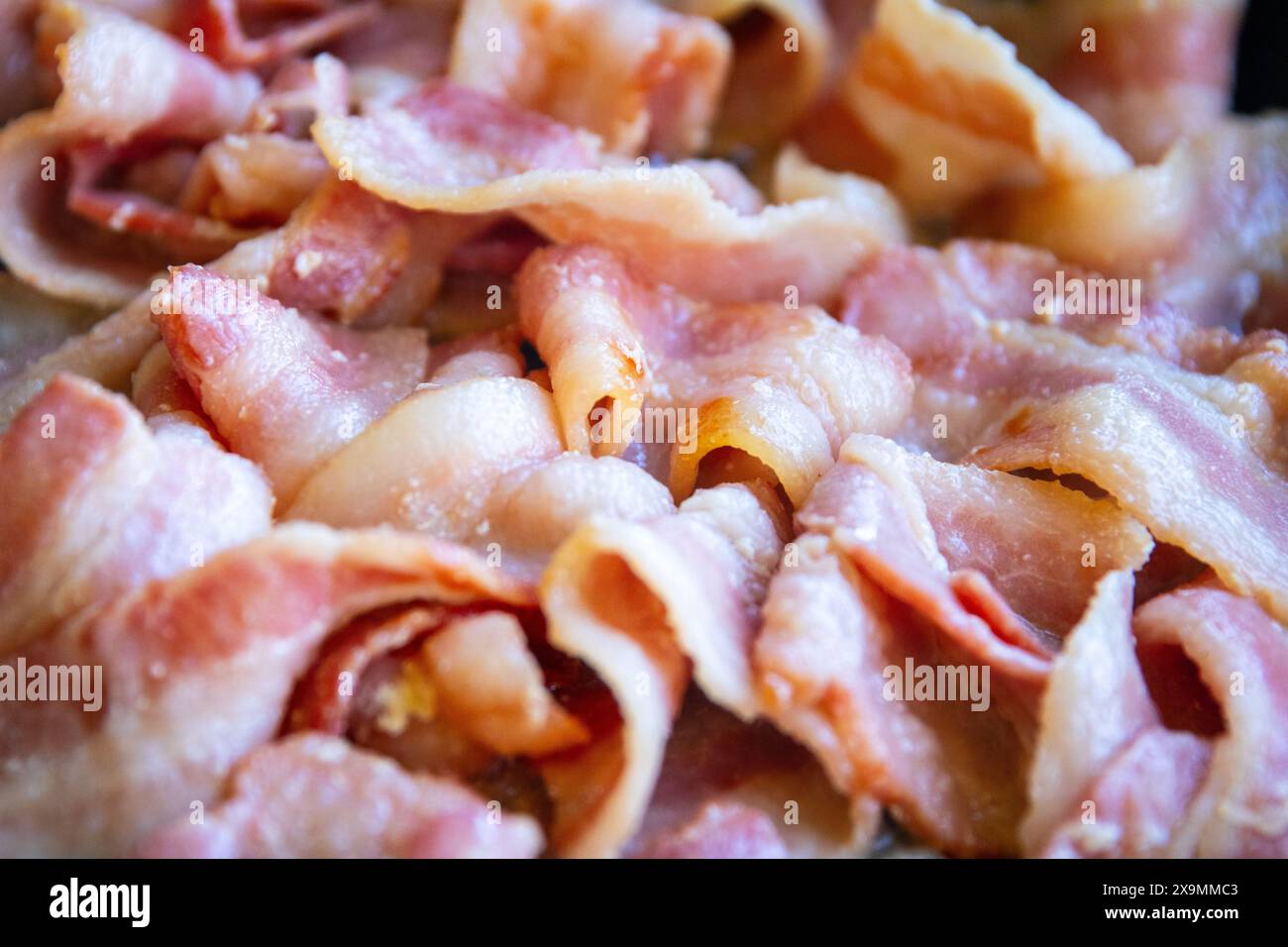 Speck brutzelt in einer Pfanne auf einem Grill Stockfoto