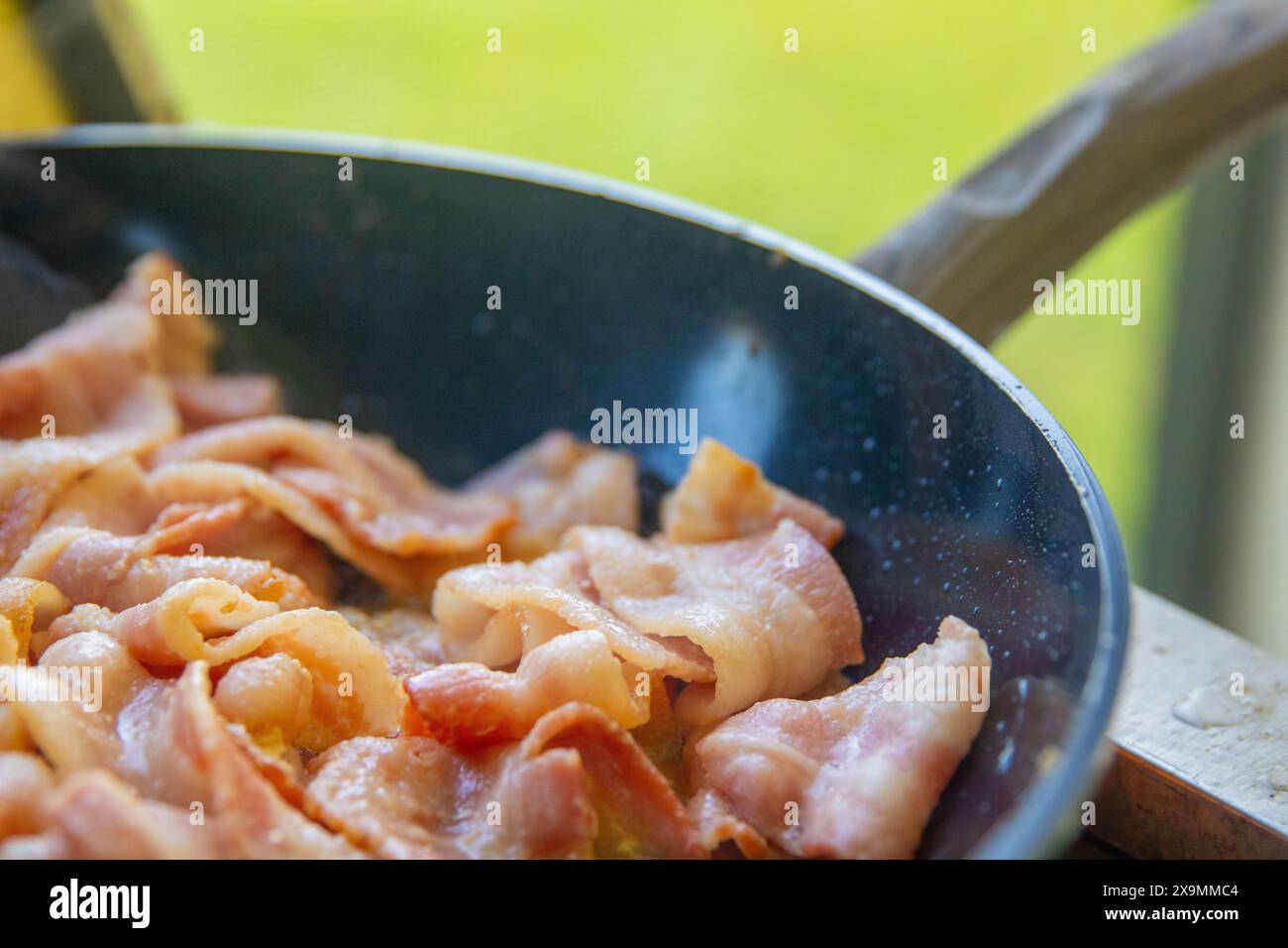 Speck, der draußen in einer Pfanne brutzelt Stockfoto