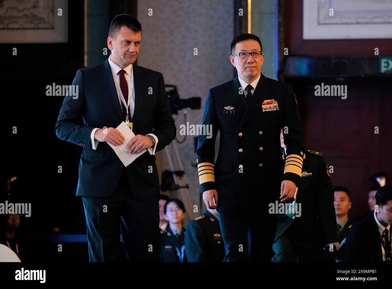 China's Defense Minister Dong Jun, right, walks on stage during the Shangri-La Dialogue summit at the Shangri-La Hotel in Singapore, Sunday, June 2, 2024. (AP Photo/Vincent Thian) Stockfoto