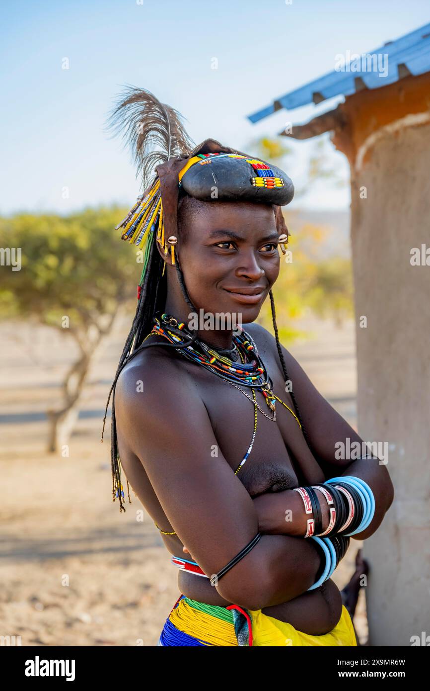 Hakaona-Frau mit traditionellem Kapapo-Haar und Haarschmuck mit Straußenfedern und bunten Halsketten, Porträt, im Morgenlicht Stockfoto