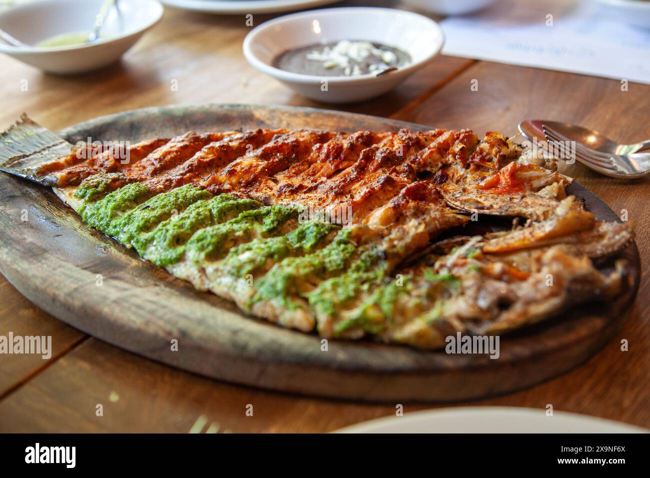 Gegrillter Fisch, halb mit Petersiliensauce halb mit roter Chili-Sauce, im Contramar Restaurant in mexiko-Stadt, Mexiko Stockfoto