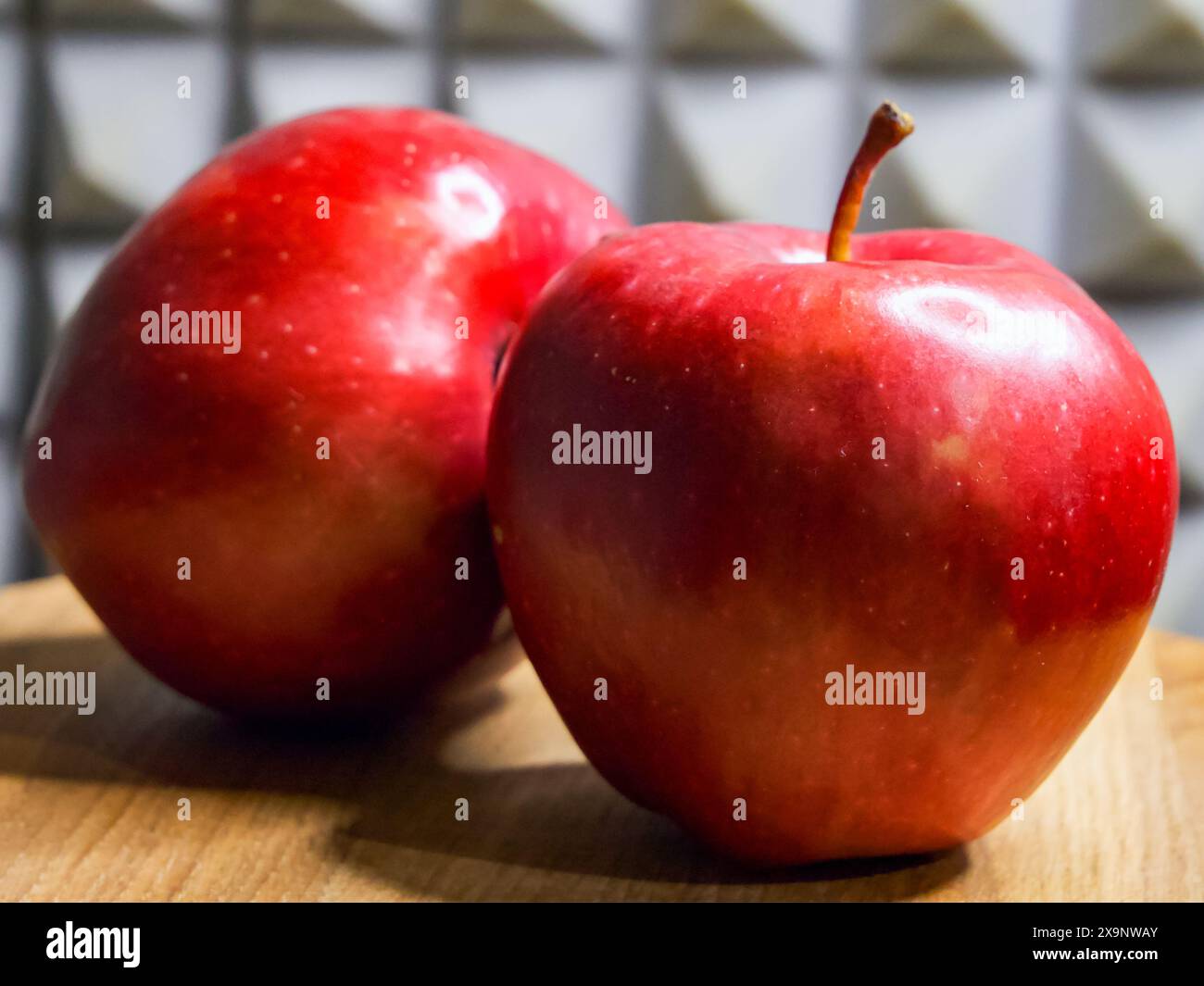 Glänzende Rote Äpfel. Glänzende Äpfel auf Holz mit gemustertem Hintergrund, ideal für Gesundheit. Stockfoto