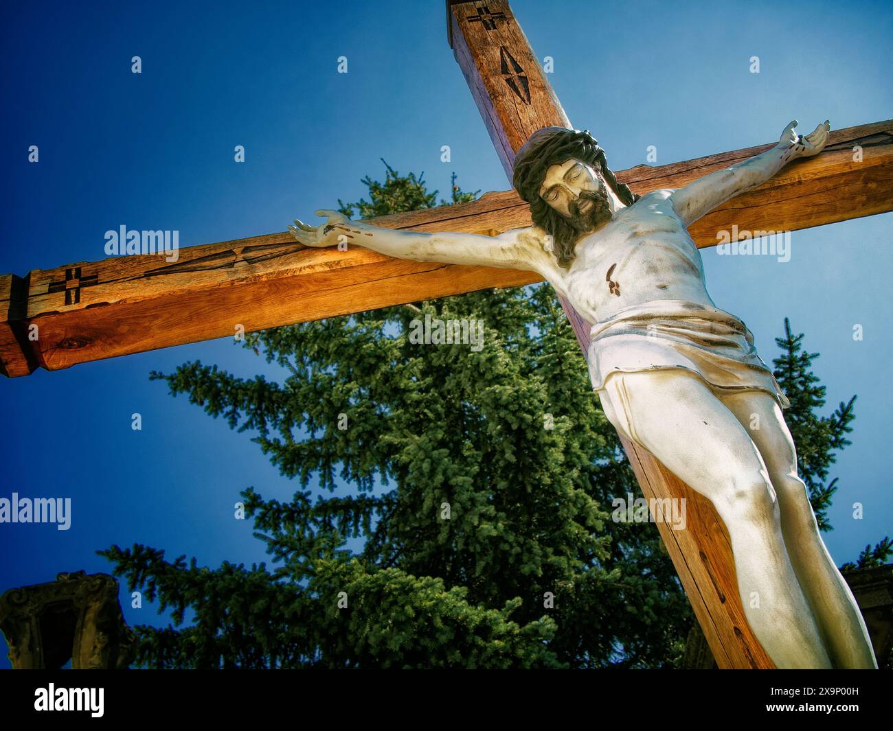Kreuzigungsszene: Ein Kreuzigungskreuz mit Jesus, die christliche Ikonographie darstellt, in Sonnenlicht getaucht, feierliches fest vermittelt. Stockfoto