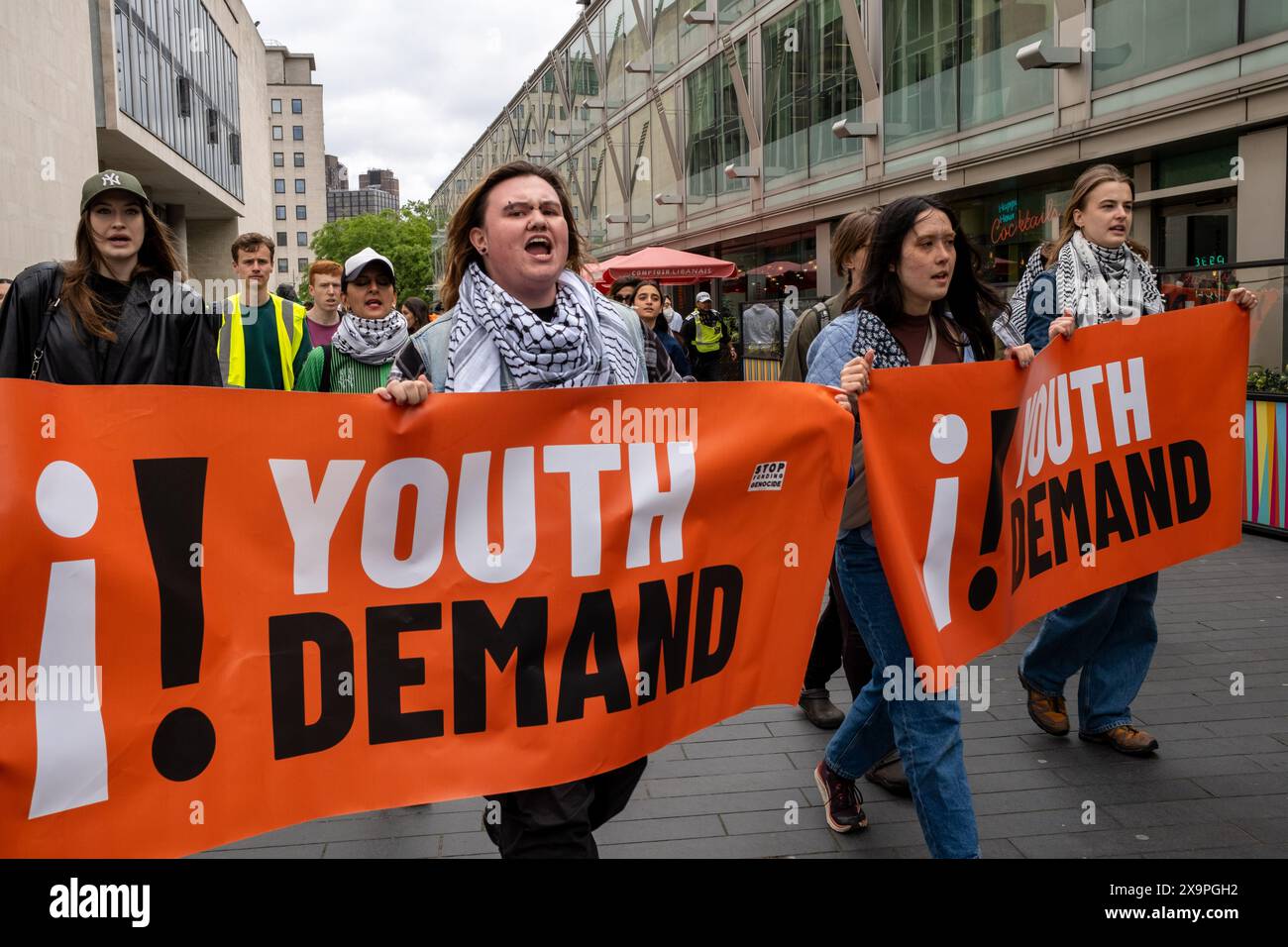 Jugendliche fordern Demonstranten, die während der Demonstration Banner halten. Die Demonstranten der Jugendforderung hielten einen Protest zur Unterstützung des Gazastreifens und der Palästinenser ab. Nach ihren Reden wurde ein Katz- und Mausspiel mit der Polizei in den Straßen von South East London beobachtet. Die Demonstranten blockierten die Straßen und sorgten für Verkehr, indem sie mitten auf den Straßen saßen und sich hinlegten. Die Polizei erließ eine öffentliche Ordnung in Sektion 12 und mehrere Verhaftungen wurden durchgeführt. Stockfoto