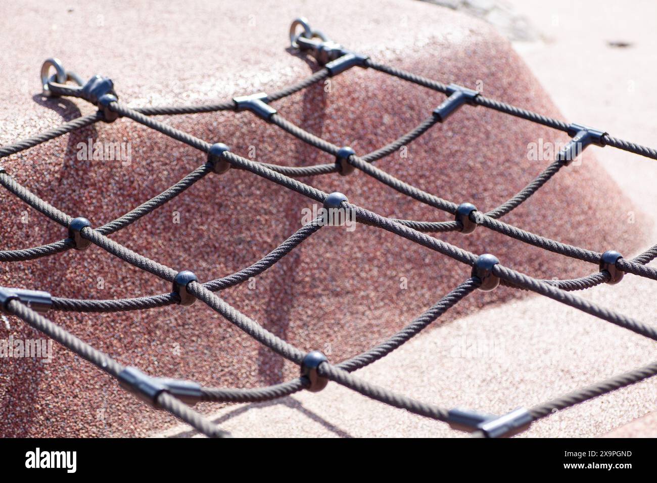 Nahaufnahme eines Kletternetzes auf dem Spielplatz mit robusten Materialien und sicheren Befestigungen Stockfoto