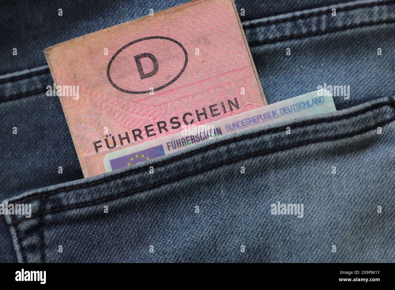 Ein alter und ein neuer deutscher Führerschein mit der Aufschrift "Führerschein" in einer Hosentasche Stockfoto