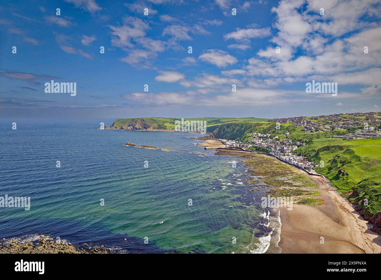 St. John's Church & Kirkyard Gardenstown Aberdeenshire Blick über die Bucht, das blaue grüne Meer und den Strand nach Gardenstown und Crovie im Frühling Stockfoto