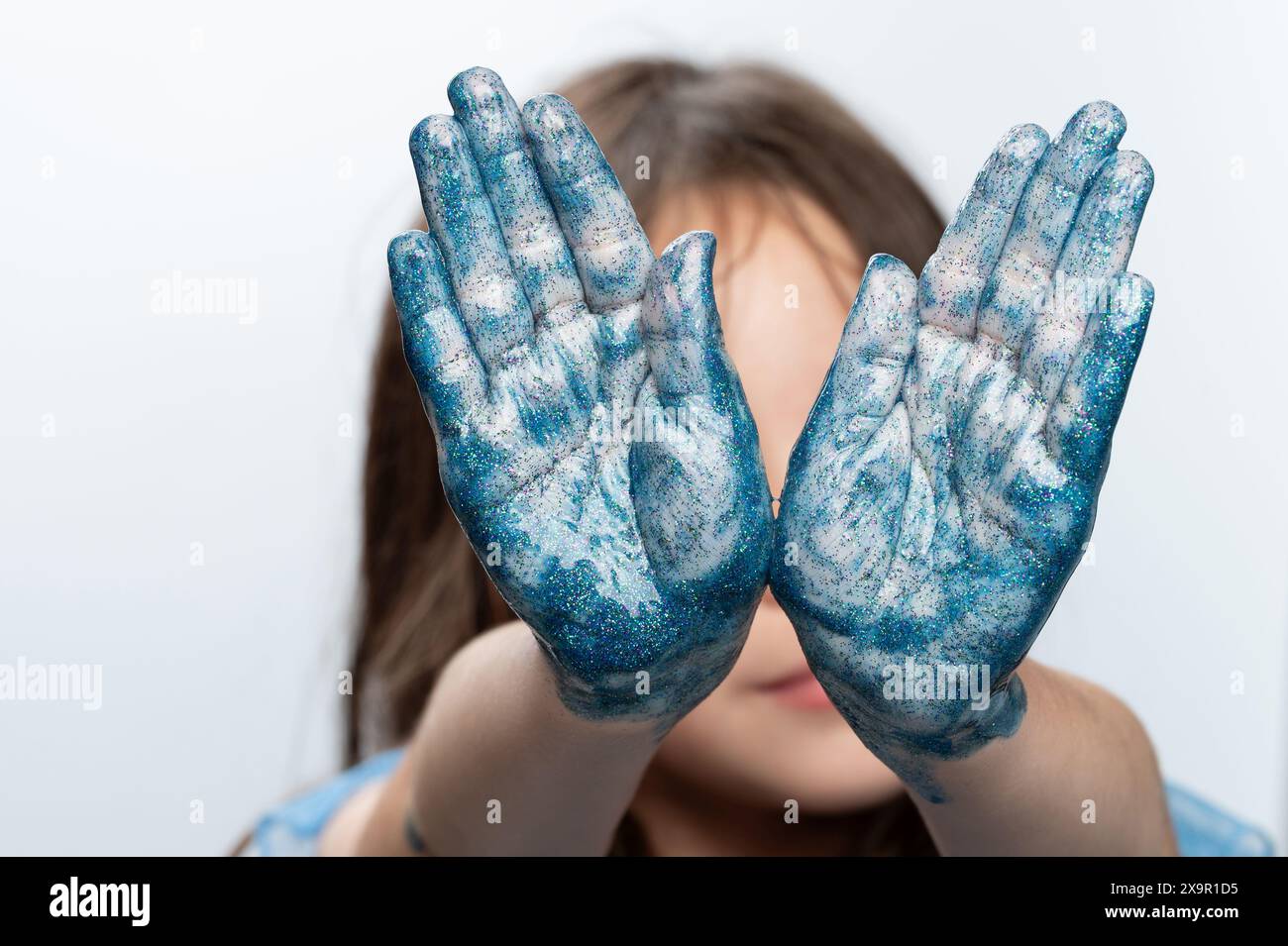 Blau gemalte Kinderhände aus nächster Nähe auf weißem Studiohintergrund Stockfoto