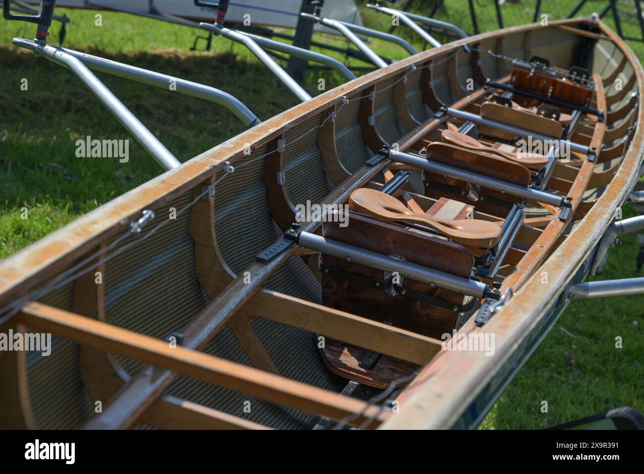 Langes hölzernes Sportboot für Ruderregatta mit Schiebesitzen und Stützen mit Ruderschlössern, Einsatz bei Seerennen in Deutschland, ausgewählter Fokus Stockfoto