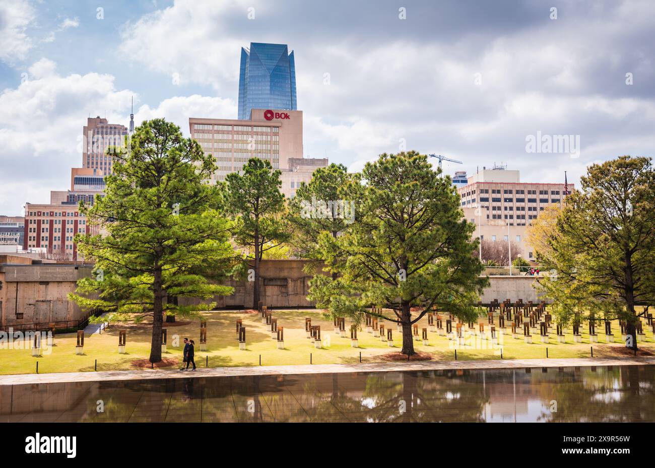 Oklahoma City, Oklahoma USA - 17. März 2017: Ein Paar schlendert zwischen leeren Stühlen und dem Reflecting Pool im Oklahoma City National Memorial in Stockfoto