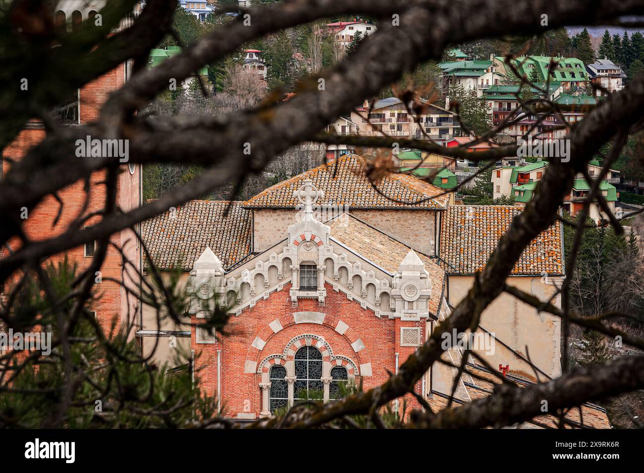 Die Fassade der Basilika San Nicola in Rivisondoli umrahmt von Baumästen Stockfoto